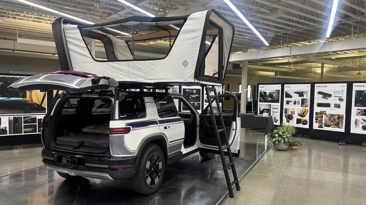 Đuôi xe Rivian R2 với cụm đèn LED chạy ngang đặc trưng bừng sáng trong đêm